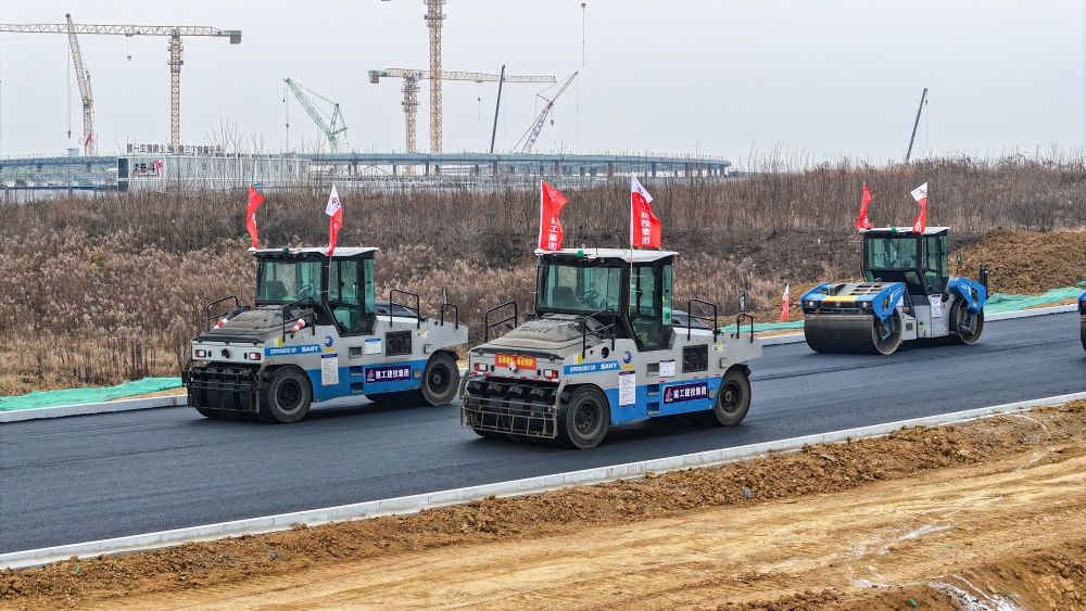 智能制作引发修建业新质生产力！365英国上市建投科学岛北路项目沥青下面层施工引入无人摊压手艺