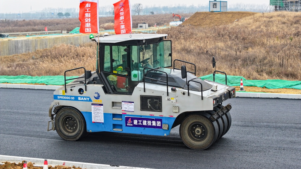 智能制作引发修建业新质生产力！365英国上市建投科学岛北路项目沥青下面层施工引入无人摊压手艺